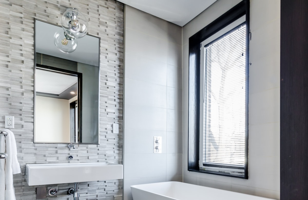 Bathroom with white Venetian blinds and a guest-ready vanity